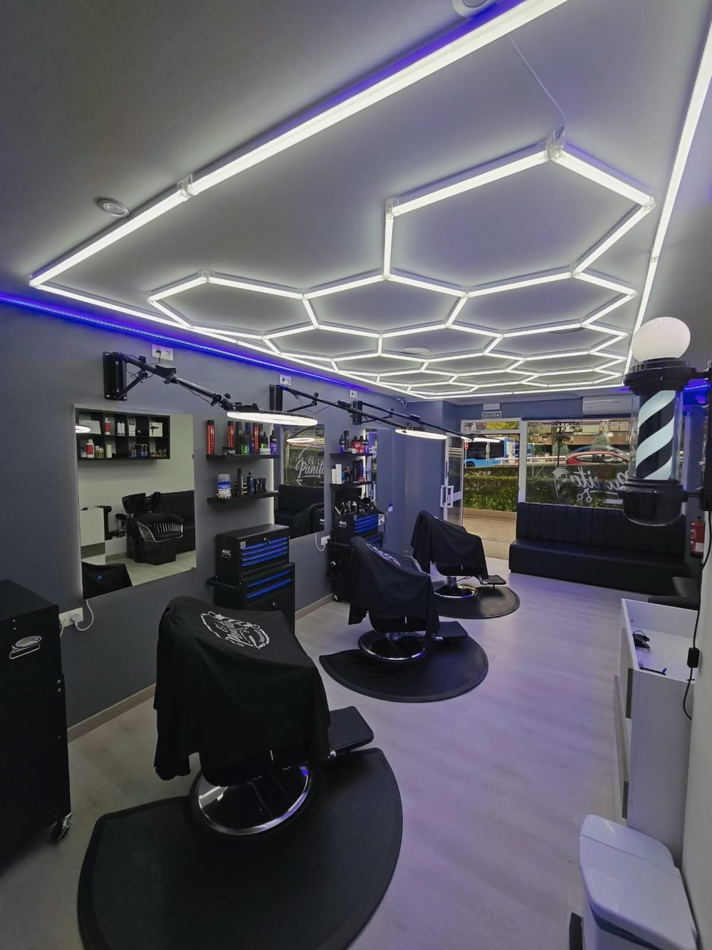 Sala de El Panita Barbershop con el techo hexagonal de LED y los sillones