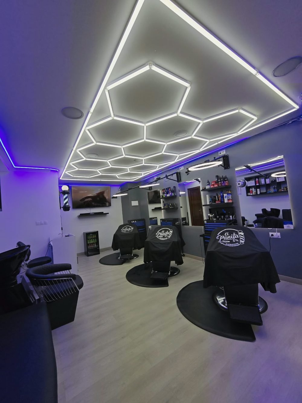 Vista general de El Panita Barbershop con la iluminación hexagonal encendida