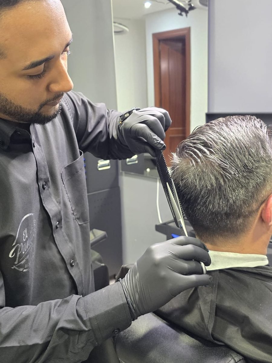 Barbero de El Panita perfilando un corte con peine y máquina