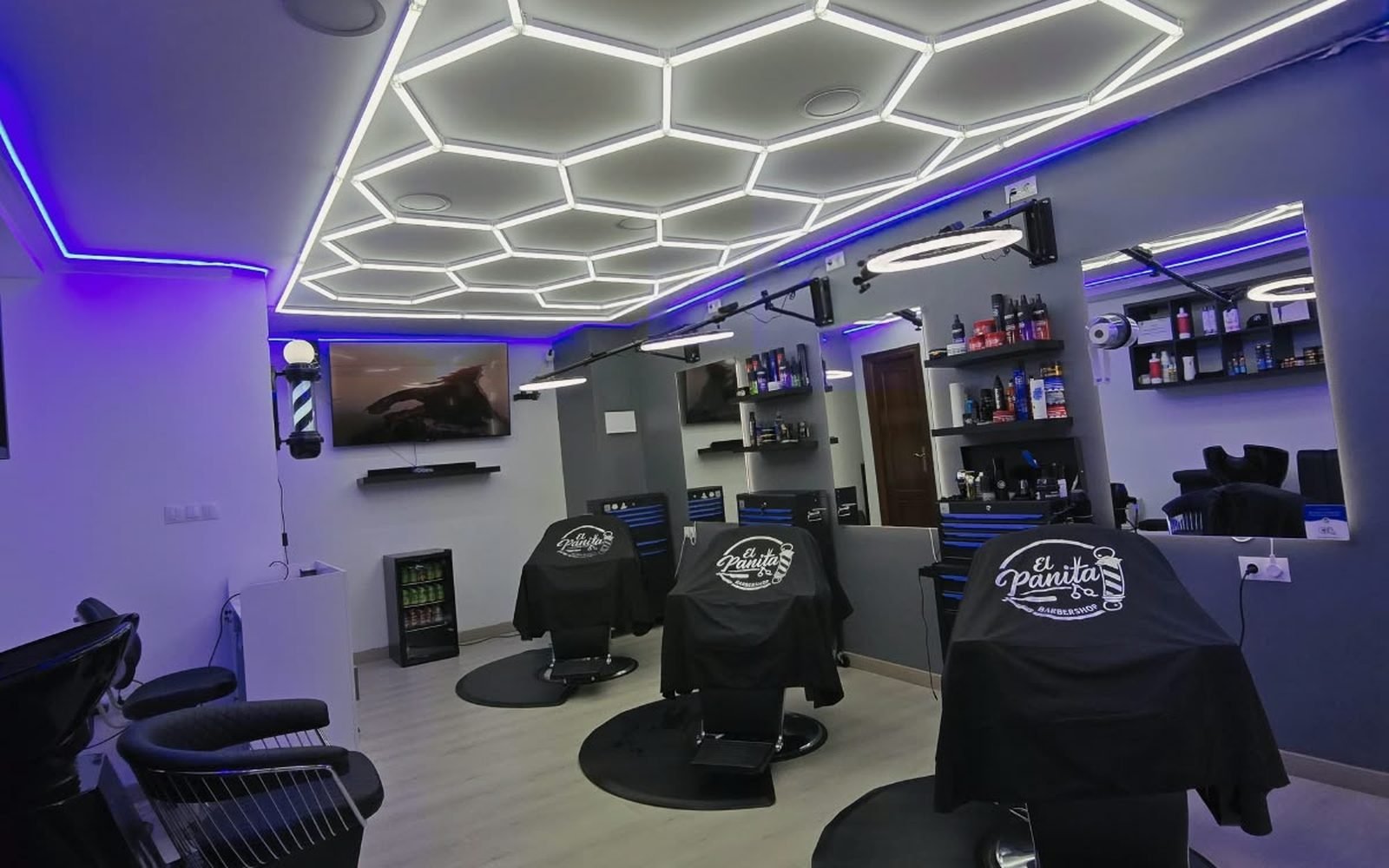 Sala principal de El Panita Barbershop con sus tres sillones y el techo hexagonal de LED