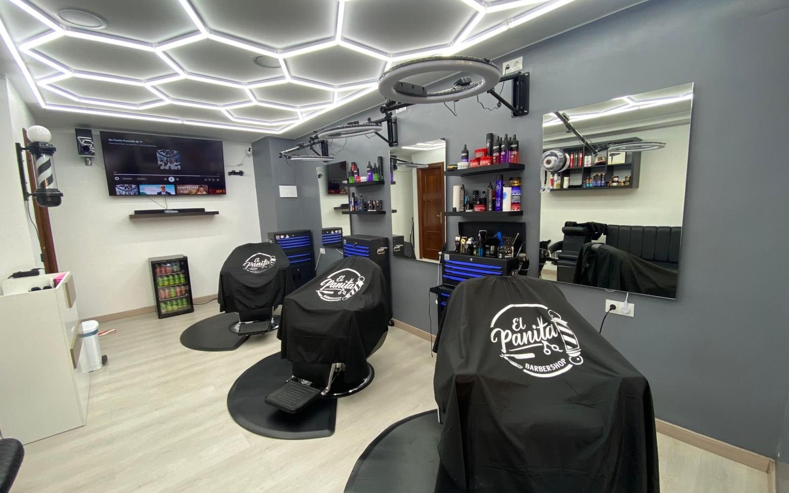 Sala principal de El Panita Barbershop con sus tres sillones y el techo hexagonal de LED