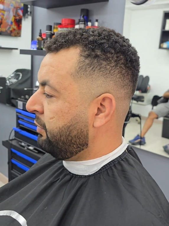 Degradado con barba perfilada y pelo rizado realizado en El Panita Barbershop